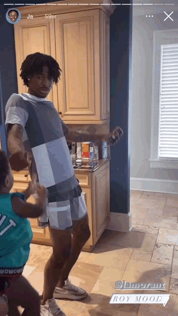 a man and a child are standing in a kitchen with the words roy mood at the bottom