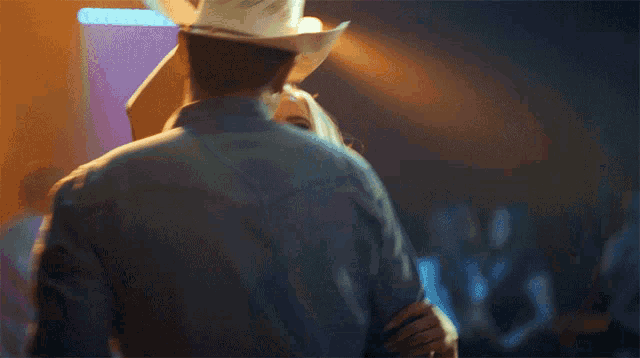 a man in a cowboy hat dancing with a woman