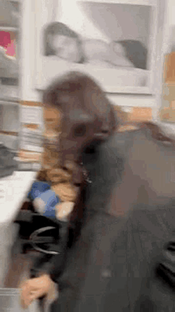 a blurry photo of a woman standing in front of a shelf