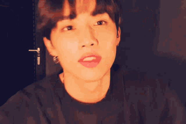a young man wearing a black t-shirt is making a funny face .