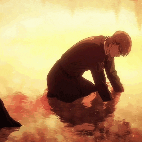 a man in a suit is kneeling in a body of water with a sunset in the background