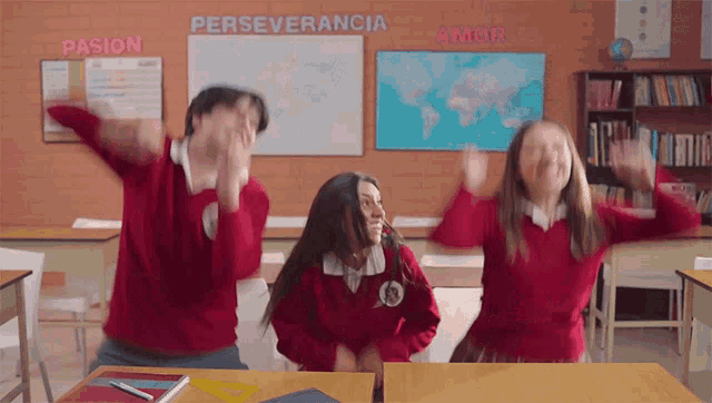 a group of students are dancing in a classroom with the word perseverancia on the wall behind them