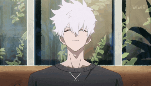 a man with white hair is sitting in front of a window with bilibili written in the corner