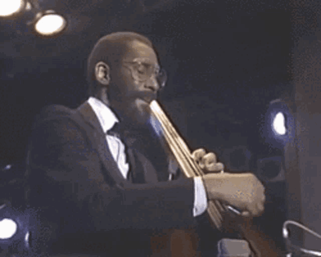 a man in a suit and tie is playing a trumpet on stage