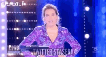 a woman in a purple dress is standing in front of a blue background with twitter stasera written on it