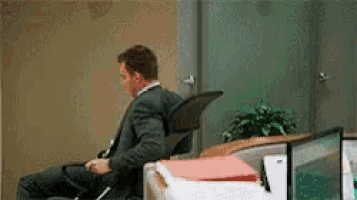 a man in a suit and tie is sitting in an office chair .
