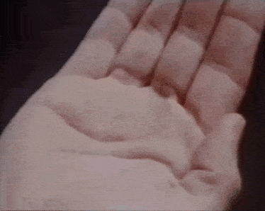 a close up of a person 's hand holding a bottle