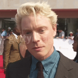 a man in a suit and tie is standing on a red carpet with the words gettyimages behind him