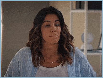 a woman wearing a blue striped shirt and a white shirt is making a face .