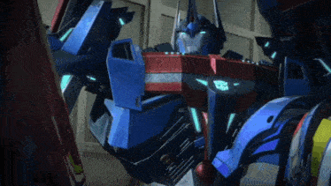 a blue and red robot is standing in front of a door