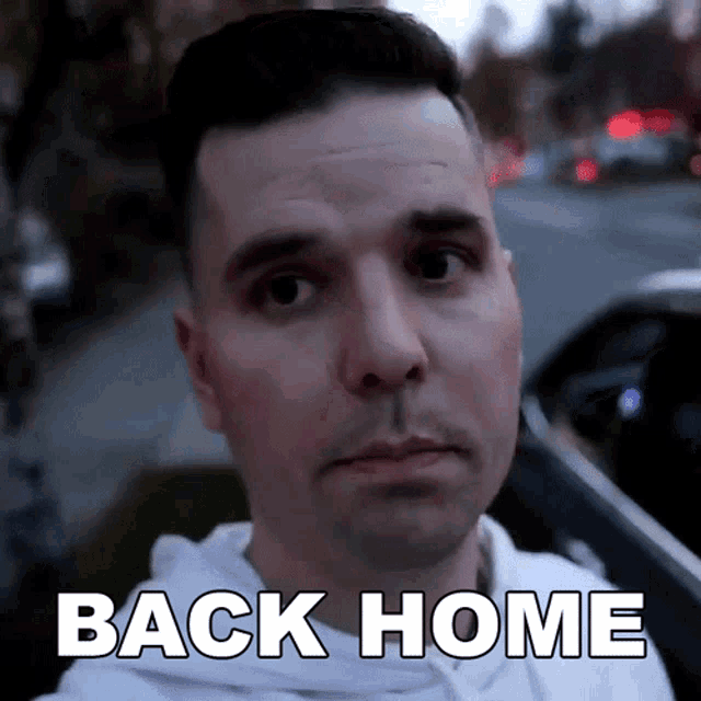 a man is looking at the camera with the words back home written on his face