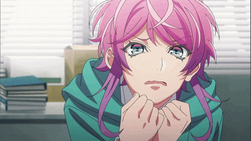 a girl with pink hair and blue eyes is wearing a green jacket