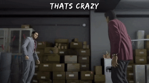 two men are standing next to each other in a room with boxes and the words that 's crazy above them .