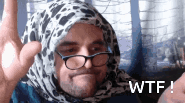 a man wearing glasses and a scarf with the word wtf written on the bottom