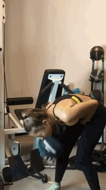 a woman is doing exercises with a dumbbell in a gym .