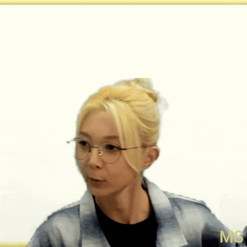 a woman with blonde hair is wearing glasses and a plaid jacket