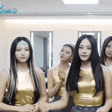 a group of young women are standing next to each other in a room .