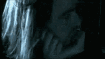 a close up of a person 's face with their hand on their chin
