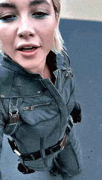 a woman in a superhero costume is taking a selfie with her mouth open .