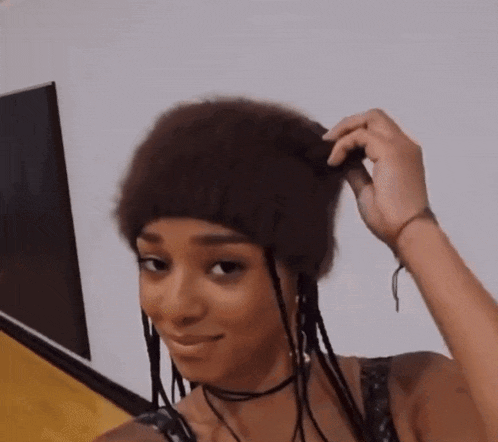 a woman with braids is wearing a furry hat and a choker .