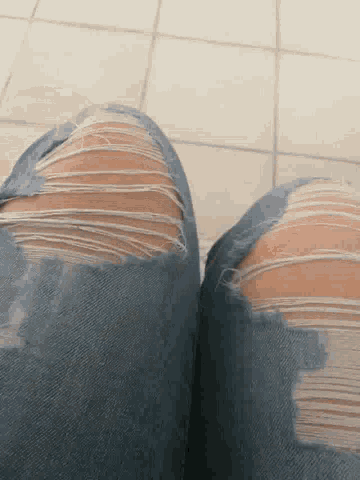 a person wearing ripped jeans with holes in them
