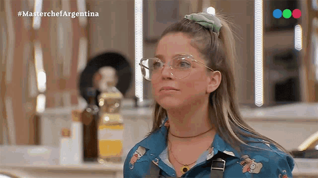 a woman wearing glasses and a blue shirt is on a tv show called master chef argentina
