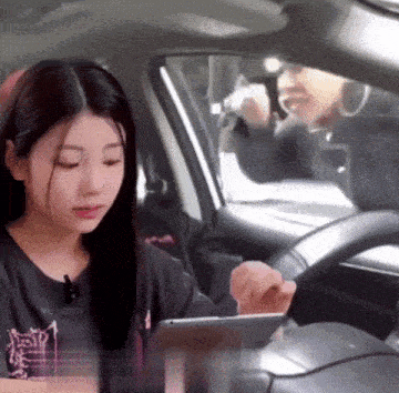 a woman sitting in a car using a tablet with the word energy on her shirt