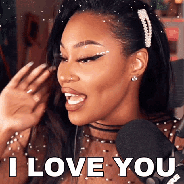 a woman singing into a microphone with the words i love you behind her