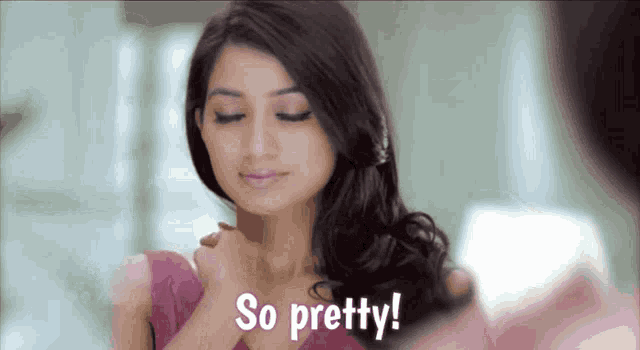 a woman is looking at herself in the mirror and says " so pretty "