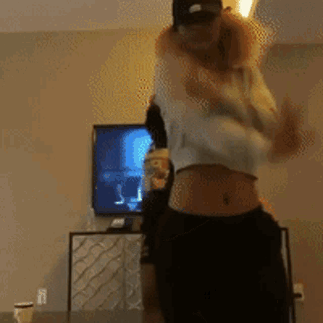 a woman wearing a ny hat and a crop top