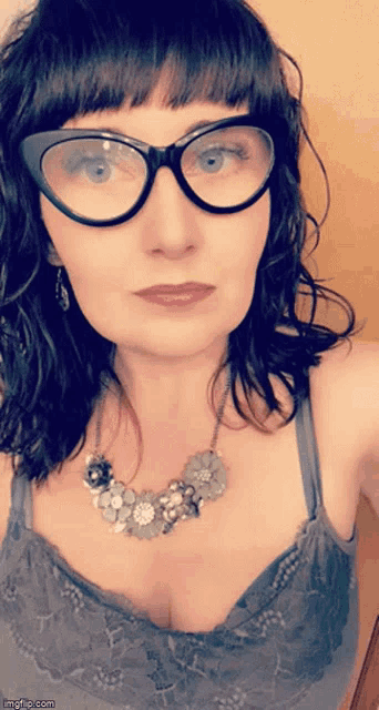 a woman is wearing glasses and a necklace