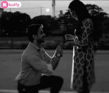 a black and white photo of a man kneeling down to propose