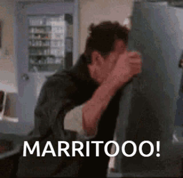 a man is standing in front of a refrigerator with the words marritoo written on the bottom .