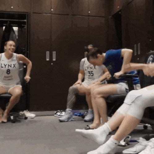 a woman wearing a lynx jersey sits in a chair