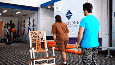 a man in a blue shirt is standing in front of a sign that says ' astone ' on it
