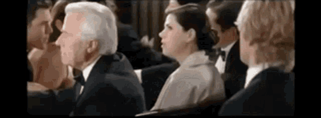 a group of people are sitting in a row at a podium .