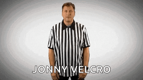 a referee is wearing a black and white striped shirt with the name jonny velcro written on it .