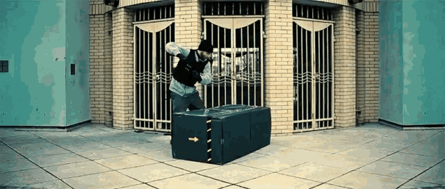a man in a black vest is standing on a large box
