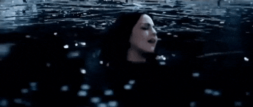 a person is swimming in a pool of water with bubbles coming out of the water .