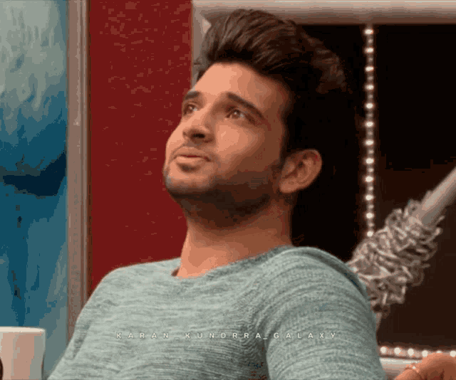 a man wearing a blue sweater with the name karan kundra galaxy on the bottom