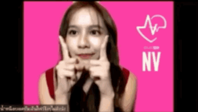 a woman is making a face with her hands in front of a pink background that says nv on it