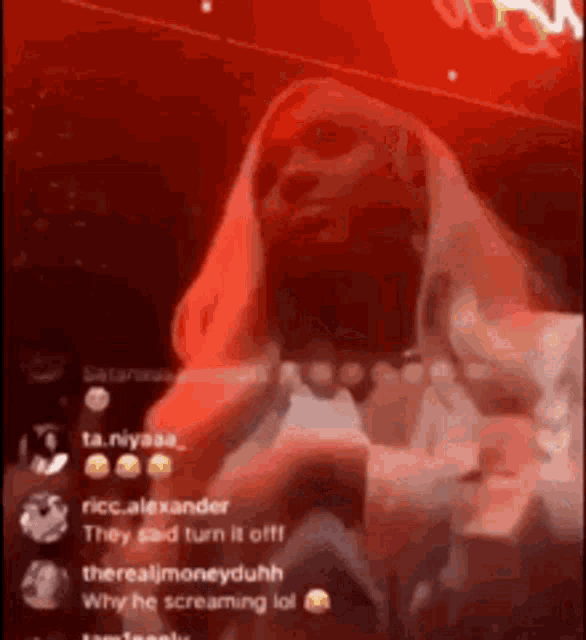 a woman is screaming in front of a crowd in a dark room .