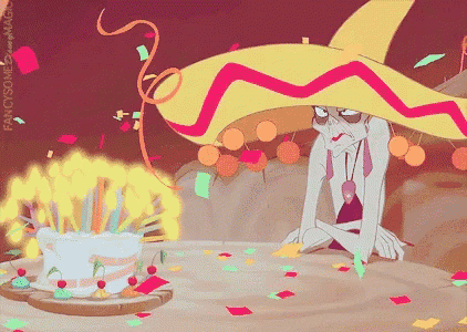 a man in a sombrero sits in front of a cake with candles on it