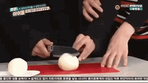 a person is cutting an onion with a knife on a cutting board with a mbc everyo logo on the bottom