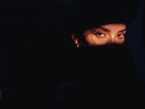 a close up of a woman 's face with a light shining on it