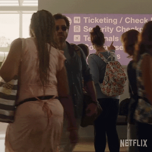 a group of people standing in front of a sign that says " ticketing / check in "