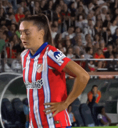 a woman wearing a red and white striped shirt with herbalife on it