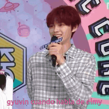 a young man holding a microphone with the words gyuvin cuando habla de eimy written below him
