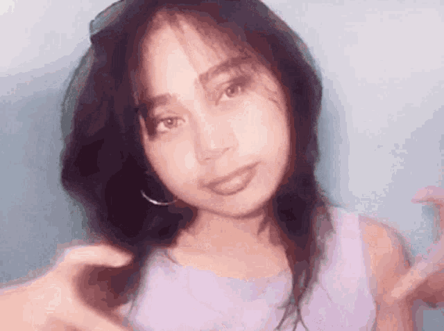 a young woman is making a heart shape with her hands