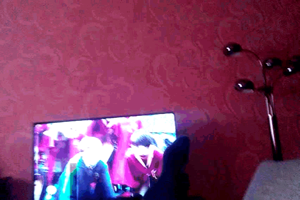a pink wall with a tv on it and a lamp behind it